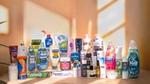 A neatly arranged display of Unilever’s ‘Power Brands’ on a wooden surface. Brands include Vaseline, Closeup, Comfort, Pepsodent, Persil, Surf, Lux, Dove, Clear, Rexona, and others set against a softly-lit wall with window-pane shadows.