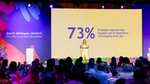 Aline Santos on stage with background stat that 73% of people encounter stereotyping