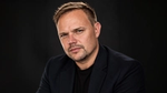 Photo of Jamie Bates, Head of Design for Unilever Personal Care. Jamie is a man with short hair, he is wearing a black shirt.