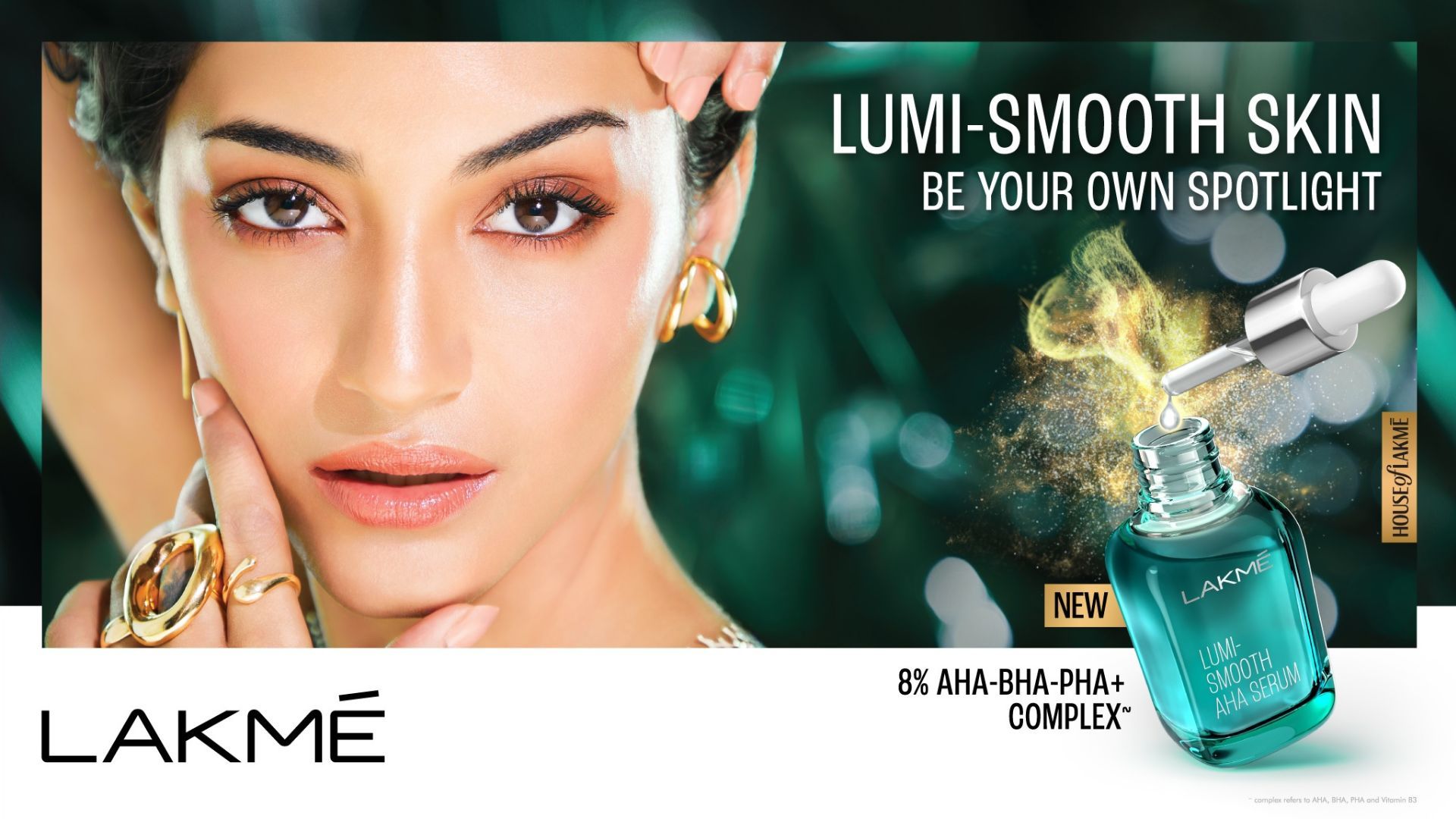 A model with dark hair and gold jewellery looks directly at the camera. The advert is for Lakme’s Lumi-Smooth AHA Serum. 