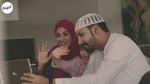 Still from TV ad showing a mother, father and child making a video call on a laptop.