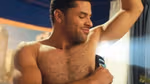 A man applies Axe deodorant to his underarms. A beam of light appears behind him.