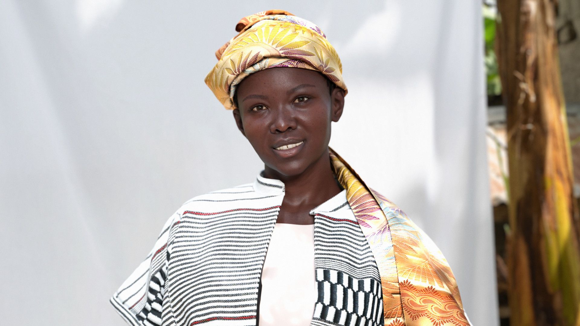 AWA, Magnum’s digital ambassador, wearing a yellow headscarf and black and white dress designed by Rebecca Zoro