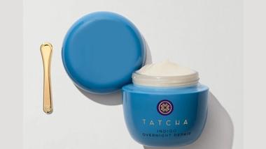 A photo of Tatcha Indigo Overnight Repair – a white rich cream in a blue glass jar with a small gold applicator.