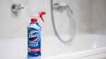 The new Domestos Power Foam Spray bottle sits on the edge of a white toilet