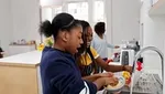 Two smiling girls washing up