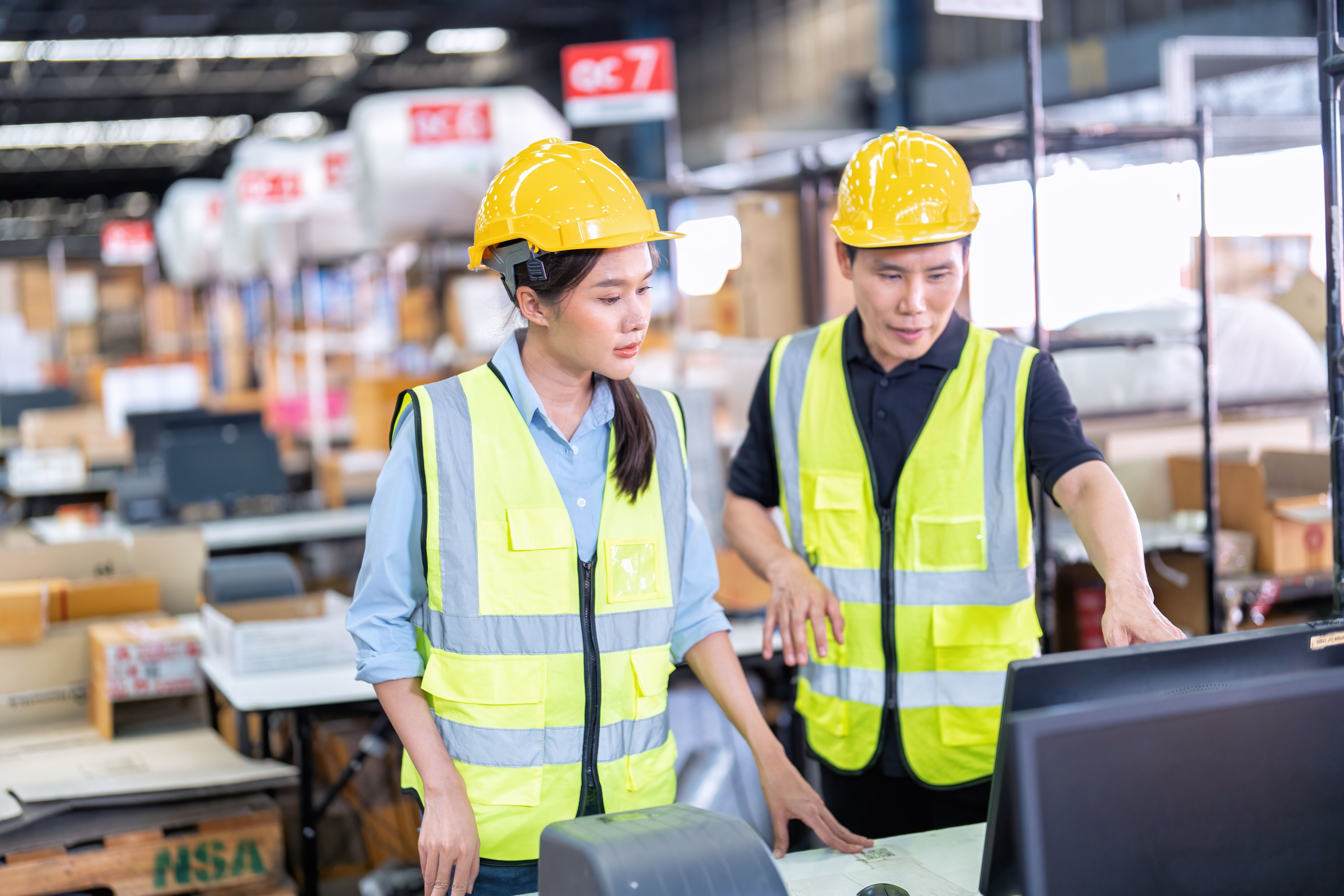 Two workers in high-vis jackets and safety helmets