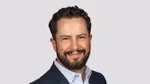 A photo of Leandro Barreto, Chief Marketing Officer for Unilever Beauty & Wellbeing. Leandro is a white man with dark hair and a beard, smiling at the camera.