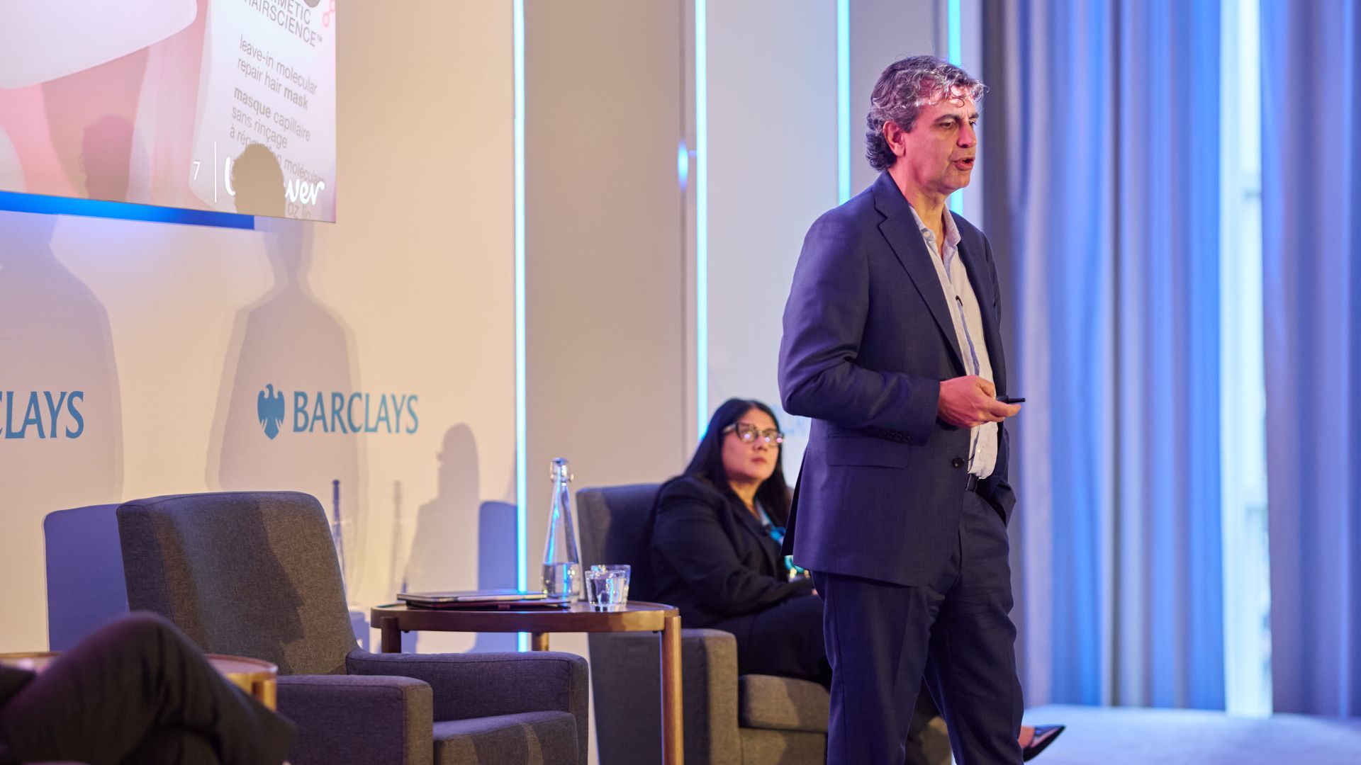 Businessman delivers a presentation on stage at a Barclays corporate event.