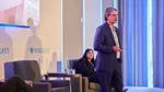 Businessman delivers a presentation on stage at a Barclays corporate event.