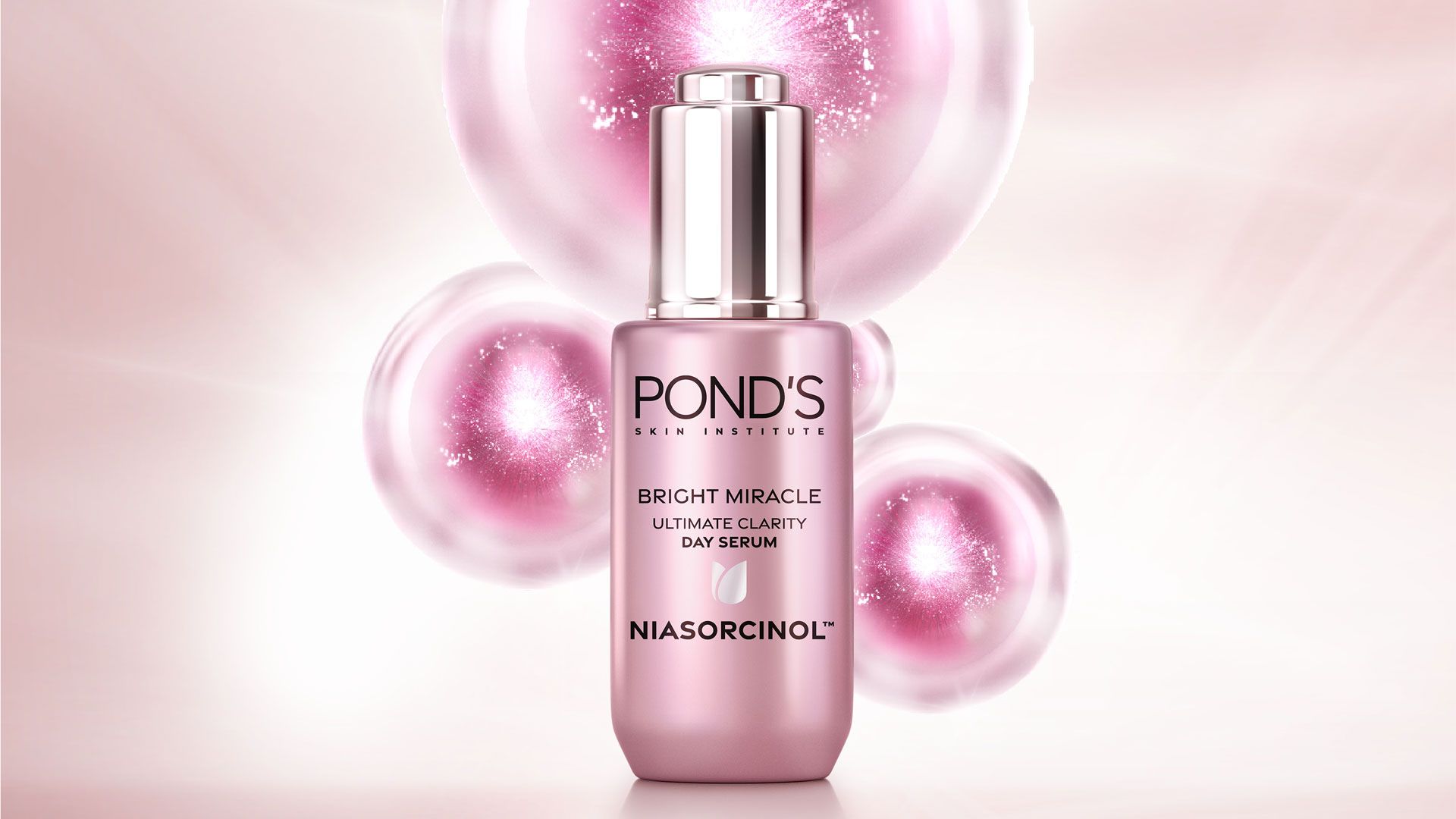 A bottle of POND'S Bright Miracle Day Serum with a shiny pink label, surrounded by shimmering pink bubbles on a soft pastel background.