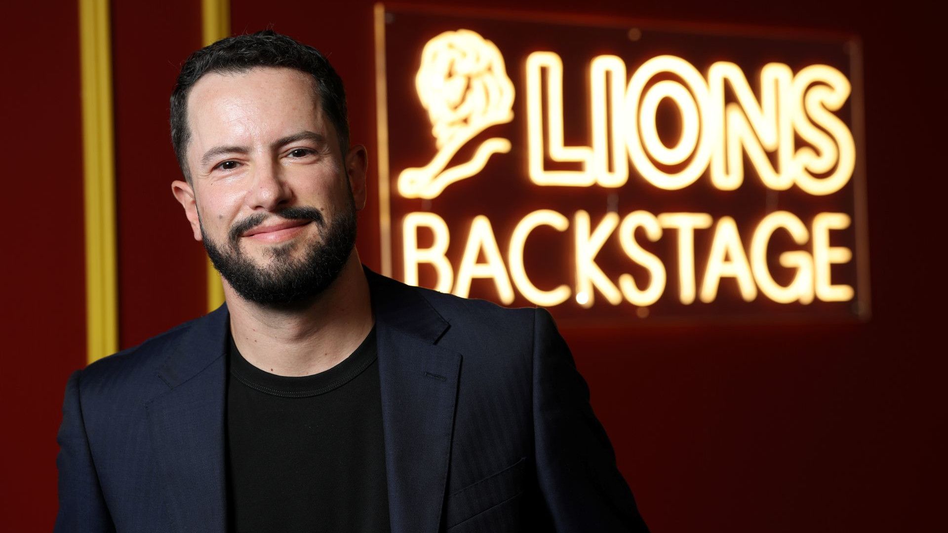 Leandro Baretto at Cannes Lions 2026 in front of a  ‘Lions backstage’ neon sign.