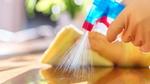 Close up of a cleaning product being sprayed and wiped down on a kitchen surface