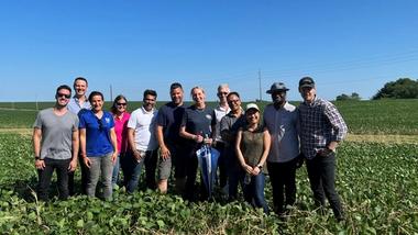 Hanneke Faber stands at the centre of a group of people in a sunny field