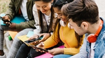 A group of four young adults in colourful clothing using social media to make sustainable choices
