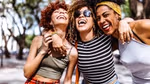 Three women smiling with their arms round each other