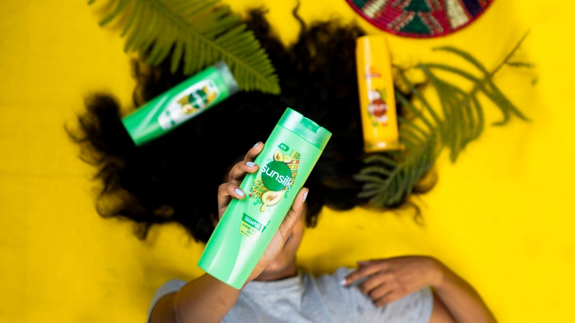 Woman holding one of Sunsilk's new shampoos whose coconut fragrance was inspired by naturehas context menu