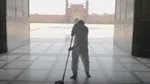 Man mopping the entrance to a large building, using Domestos