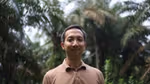 Rauf Prasodjo, Senior Manager for Sustainable Sourcing at Unilever in a palm-oil forest looking front on wearing a brown t-shirt.