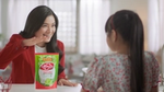 A woman in a red jacket, stands with a pack of Lifebuoy dishwash liquid. A girl is in the foreground facing her.