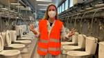 Deniz standing in front of a row of toilets in a warehouse.