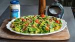 Jar of Hellmann’s Light Mayonnaise next to a plate of salad with a pepper mill and salt pot in the background.