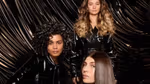 Three women with shiny hair, one blonde waves, one dark curls, one dark glossy hair. Pic is an ad for TRESemmé Lamellar Shine