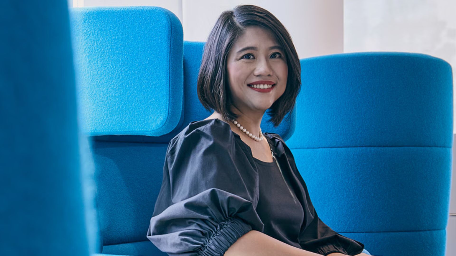 Khim Yin Poh, Lifebuoy Global Brand Lead, pictured sitting in a blue chair. She has dark shoulder-length hair and is smiling.