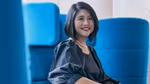 Khim Yin Poh, Lifebuoy Global Brand Lead, pictured sitting in a blue chair. She has dark shoulder-length hair and is smiling.
