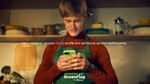 A still from Knorr’s Green Flag social influencer campaign shows a man in a green apron smiling as he looks at his phone .
