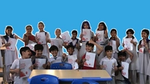 School children smiling and holding up certificates from completing happiness lessons from Wall’s and The Happiness Project