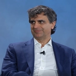Fernando Fernandez wears a blue blazer and white shirt with a lapel microphone speaking at a WSJ Leadership Institute event