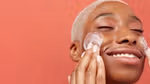 Woman smiling and moisturising her face