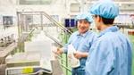 Two men in blue overalls talking to each other at our factory in China