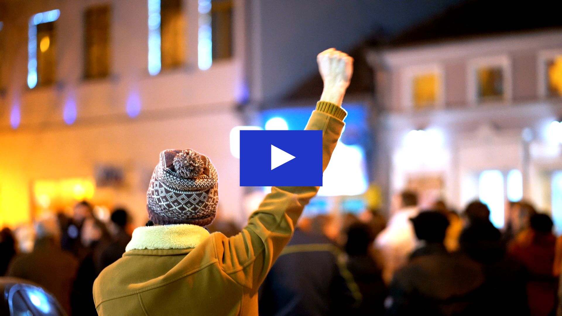 A person with their fist in the air in a crowd of people