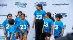 Footballer Christen Press smiling with a group of girls at a Rexona/Degree Change the Field event.